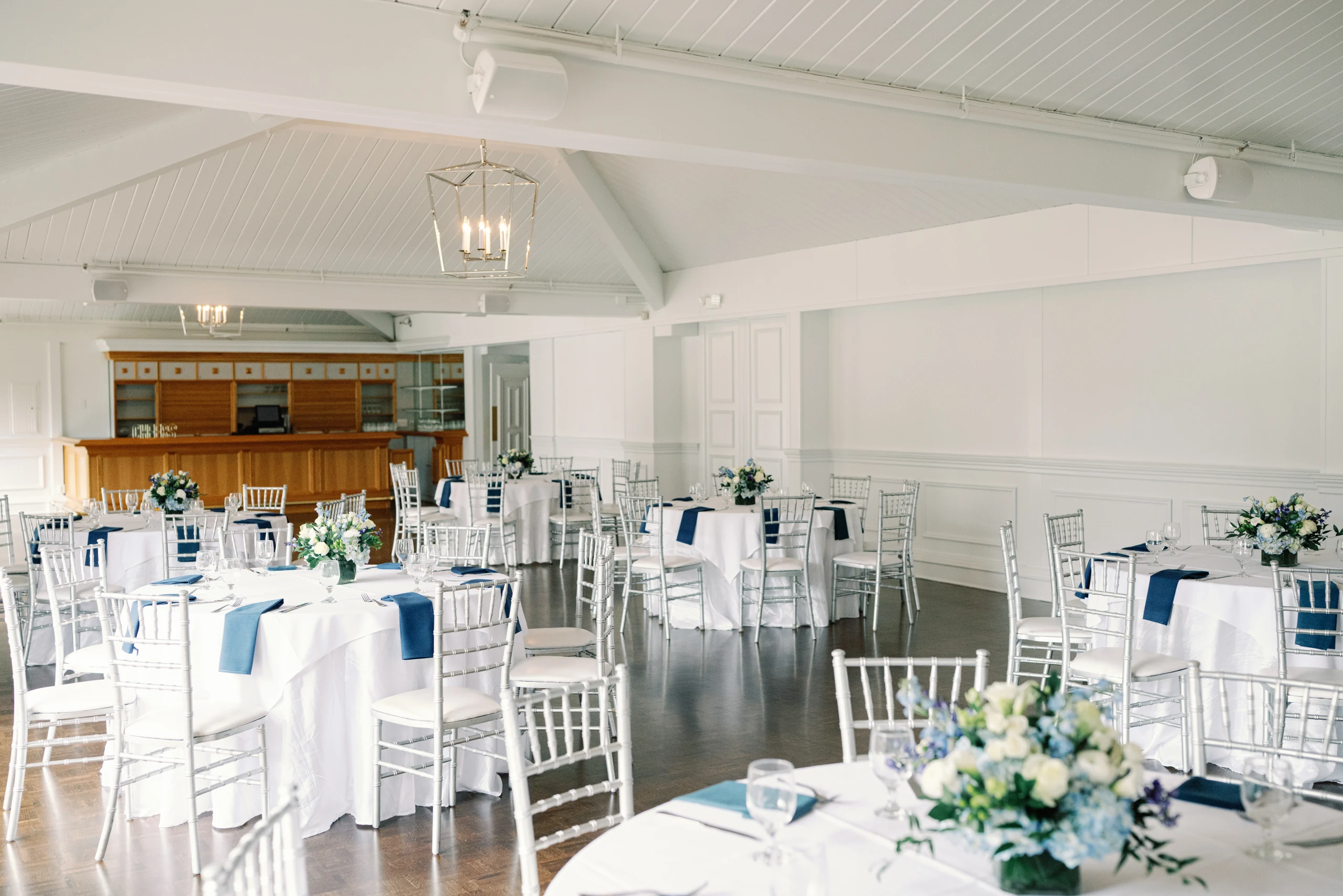 A social celebration set in a bright Lake Pearl Wrentham reception room with a wood bar and navy linens